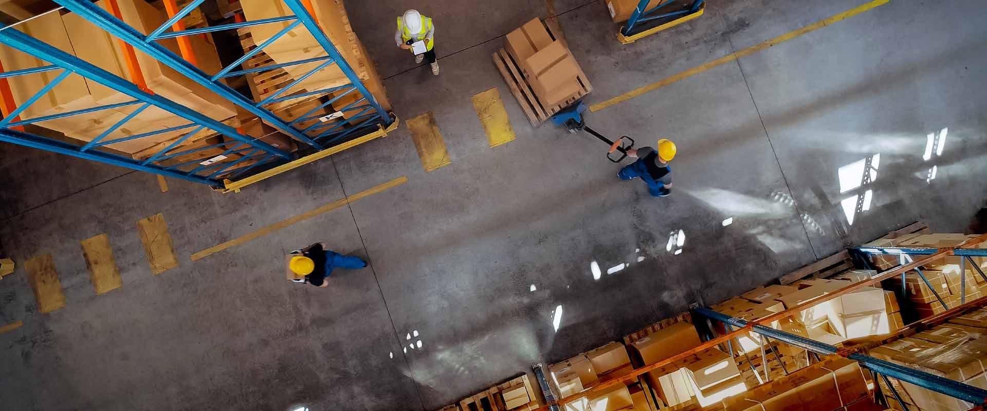 Magazijn van bovenaf met medewerkers tussen de stellingen