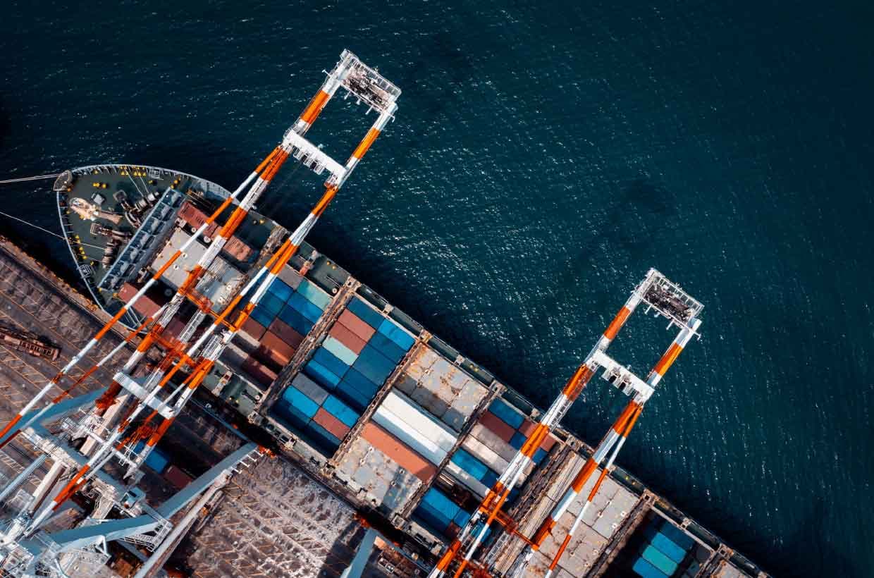 Puerto con buque portacontenedores y camiones, la cadena de suministro internacional de BM Energy